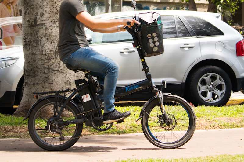 Man riding folding electric bicycle in the city